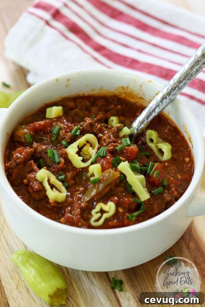 No bean chili served in a white bowl and garnished with sliced pepperoncini