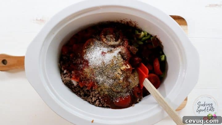 Adding the remaining chili ingredients to the slow cooker