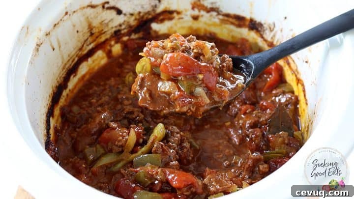 Serving a spoon full of chili out of the slow cooker