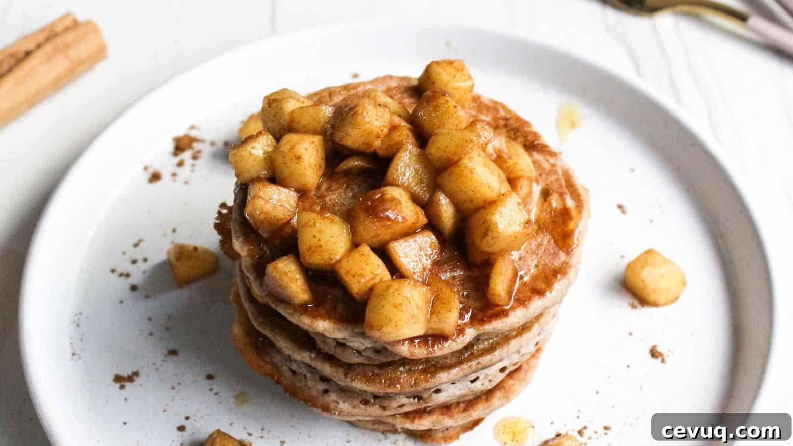 Stack of pancakes topped with cinnamon-spiced apple chunks.