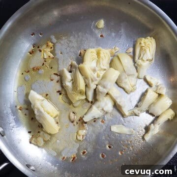 chopped artichokes added to the pan