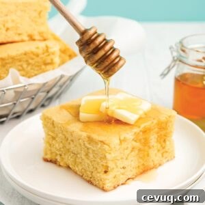 Drizzling honey over the top of a piece of cornbread with honey.