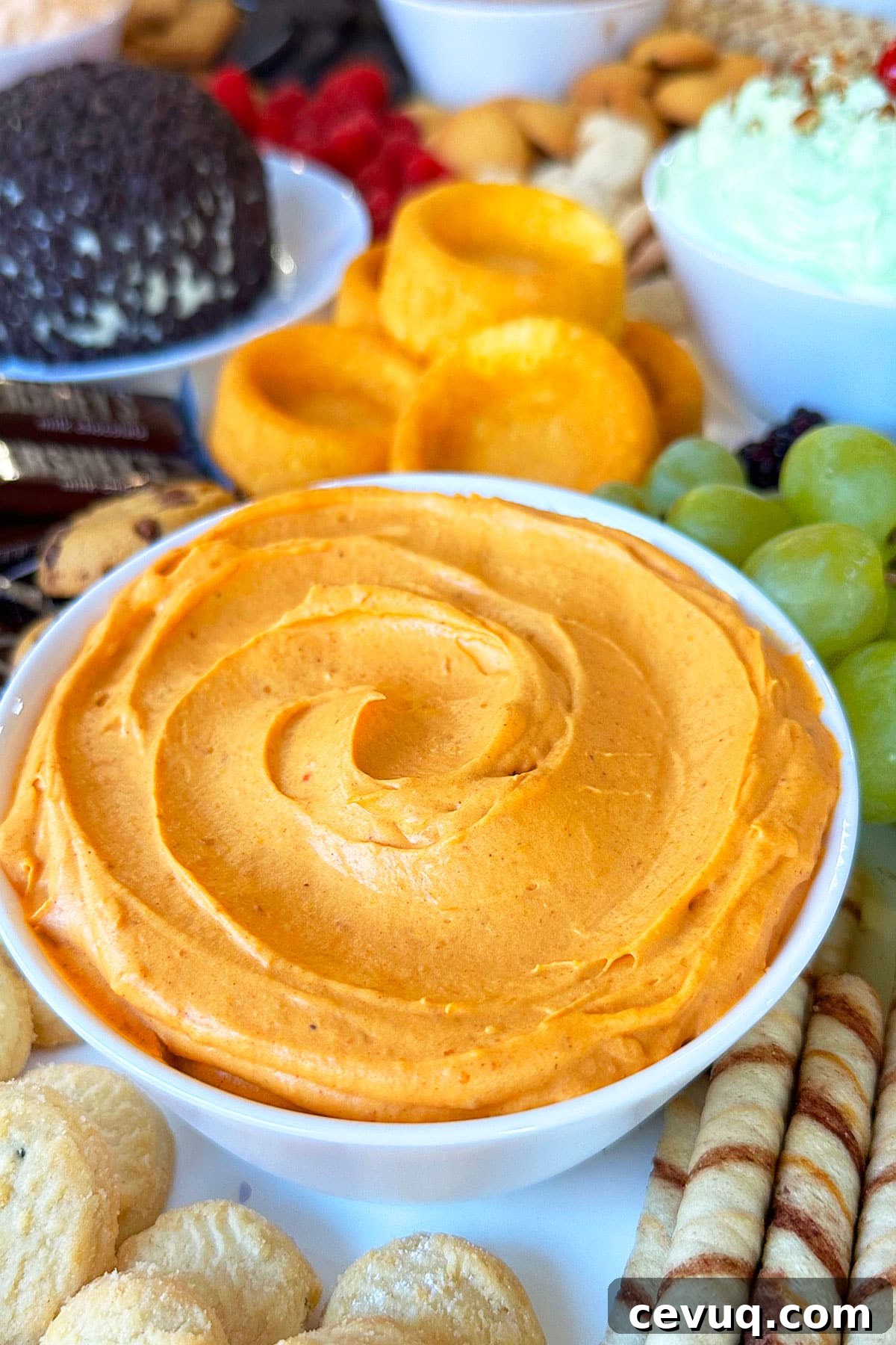 Spiced Cheesecake Dip in White Bowl on Tray With Cookies.