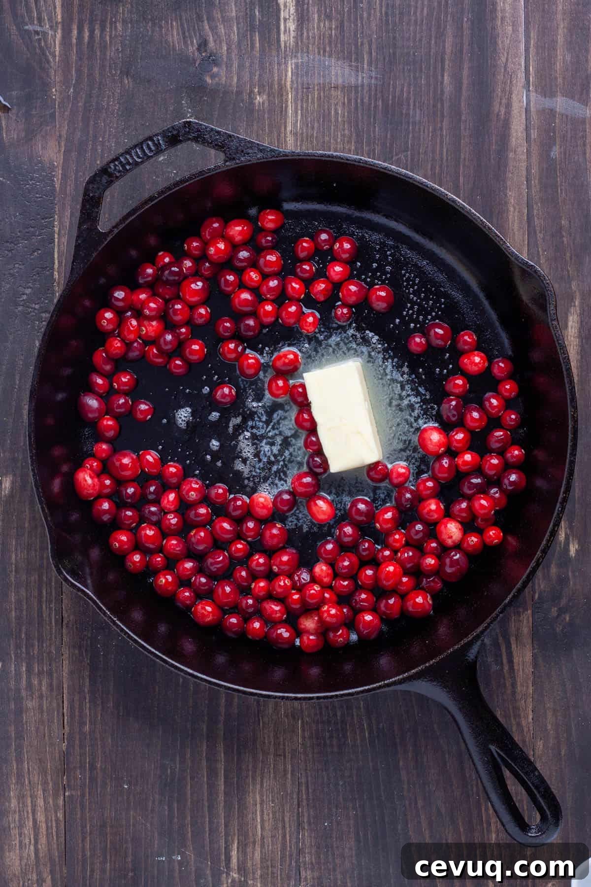 Butter and cranberries in a cast iron skillet.