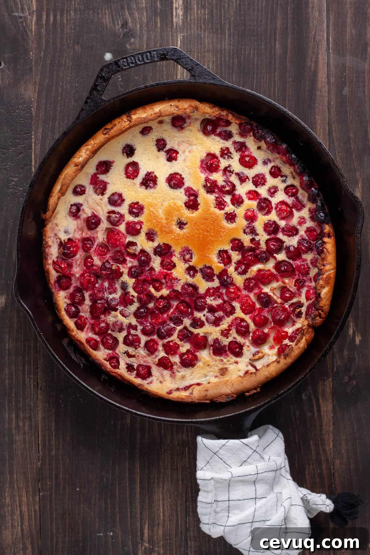 A cranberry Dutch baby in a cast iron skillet just out of the oven.