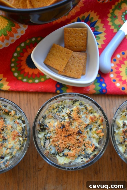 Spinach Artichoke Individual Appetizers on table with wheat chips.