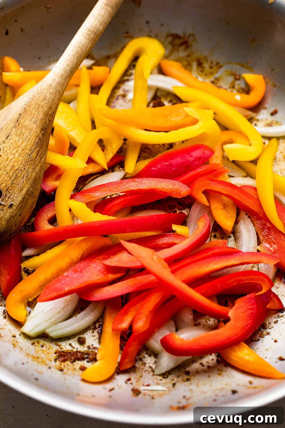sauteeing bell pepper strips and onions in a skillet
