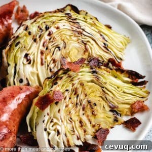 Two cabbage wedges with crumbled bacon and sausage.