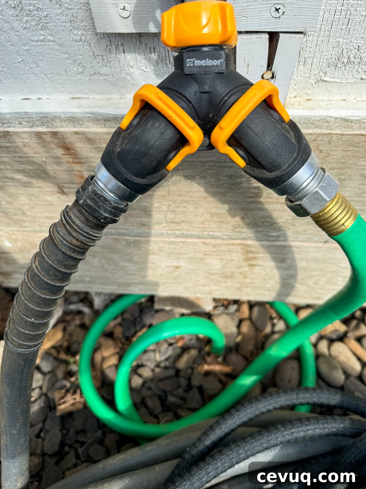 2-Way hose valve with orange levers in the garden