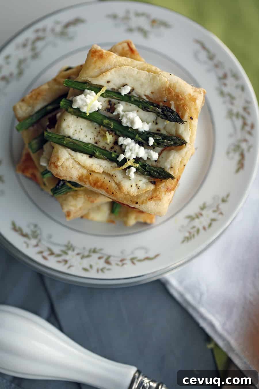 A plate with asparagus and puff pastry tarts on it.