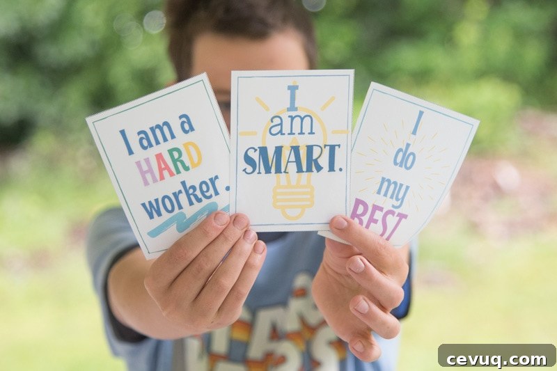 child holding printable cards with daily affirmations on them