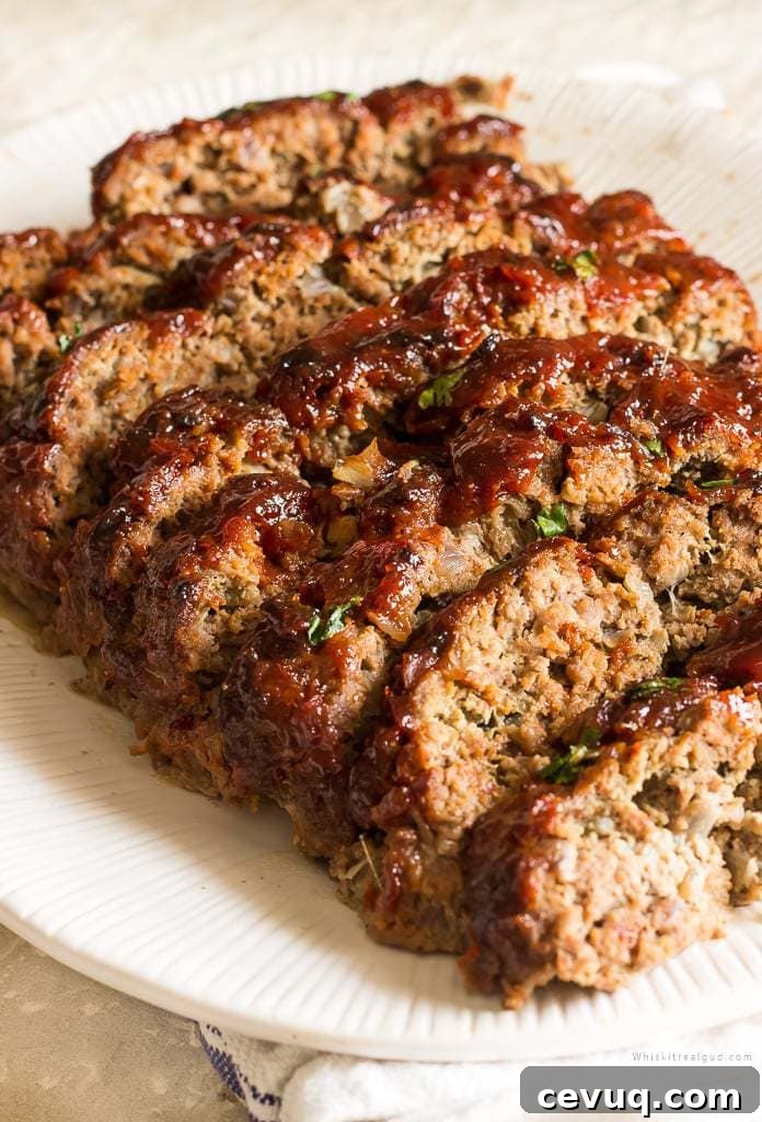 Slices of meatloaf with a brown sugar ketchup glaze on a serving plate.