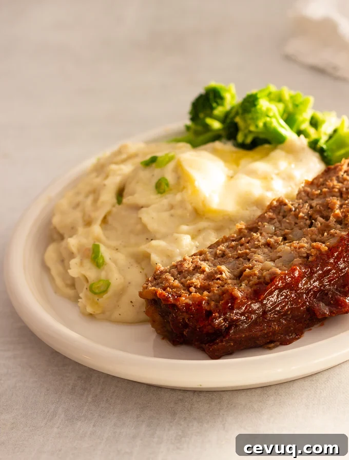 A plate of meatloaf with mashed potatoes and broccoli