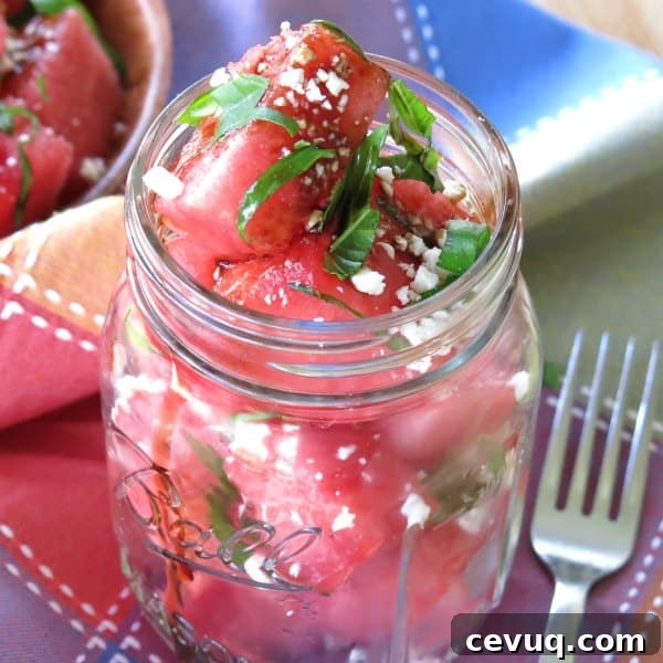 Watermelon Basil Feta Salad in a mason jar with a fork next to it.