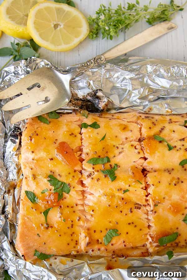 a large salmon fillet cut into pieces with a large serving spoon resting by