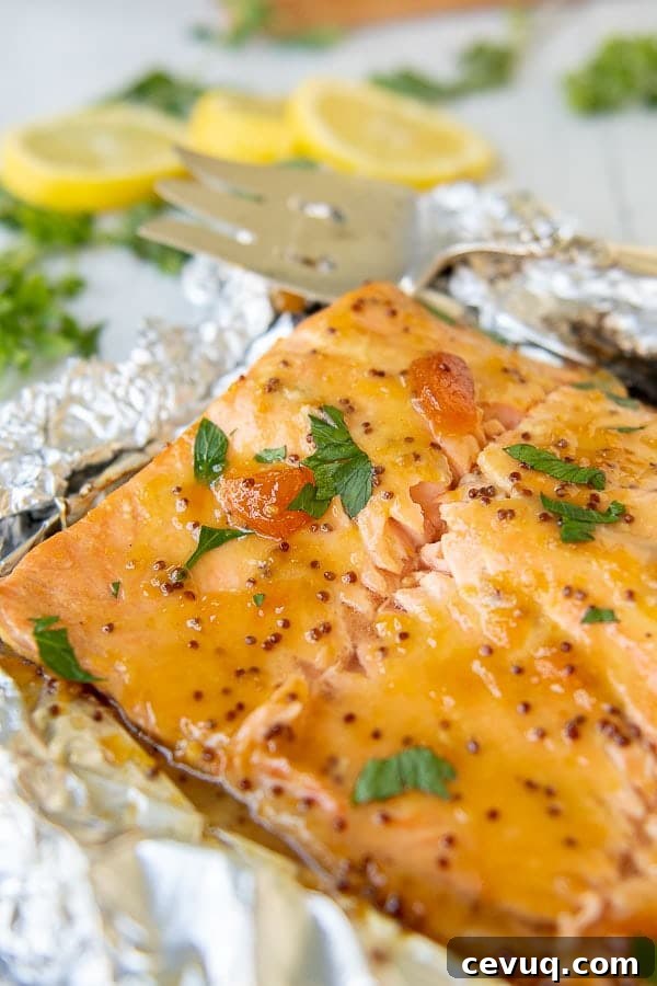 a close up of grilled salmon laying on crumbled foil with apricot mustard glaze