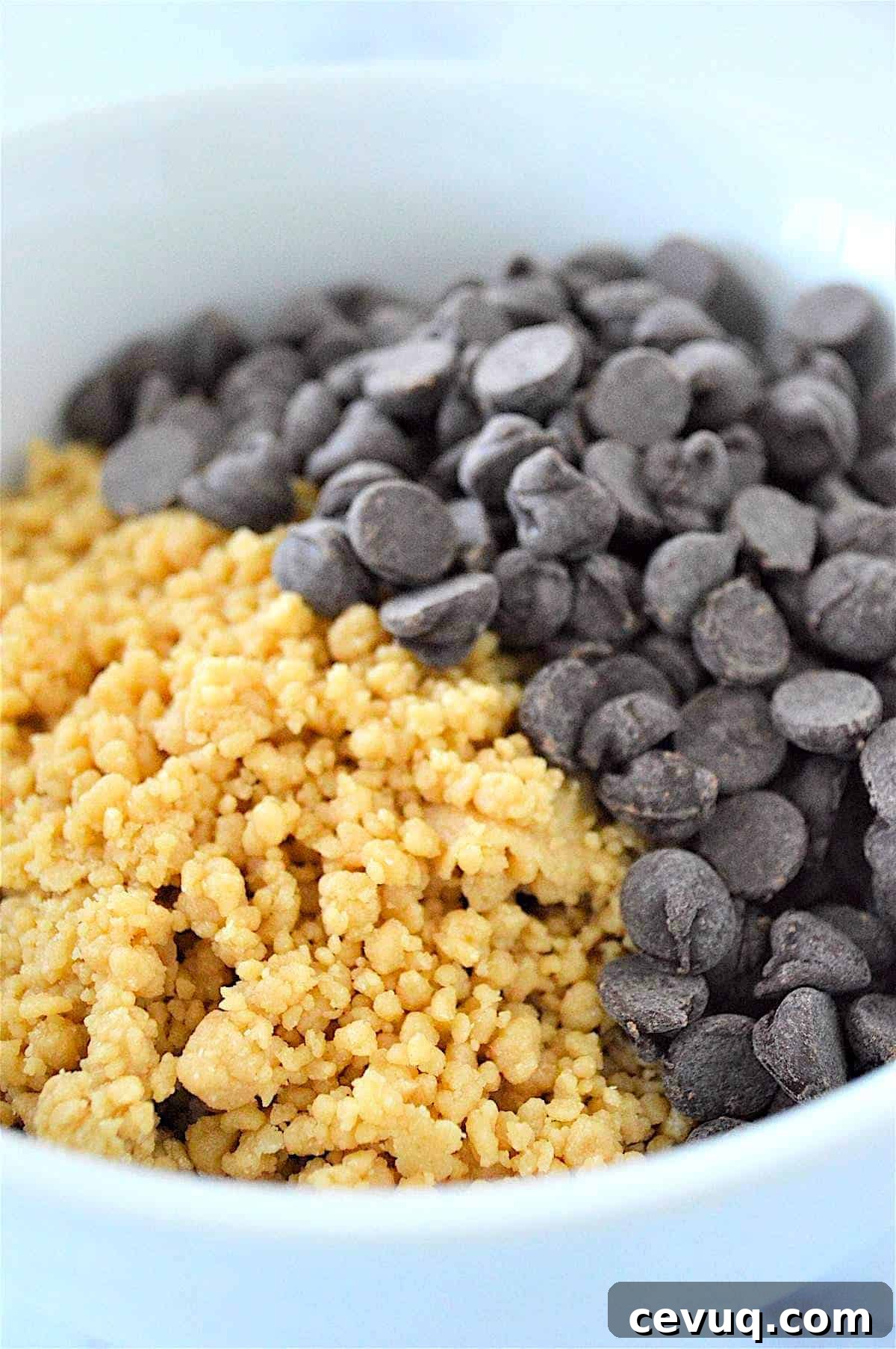 No-Bake Energy Bites Recipe for Quick, Protein-Packed Snacks 7 A process image showing how to mix chocolate chips into no bake energy ball dough in a bowl.