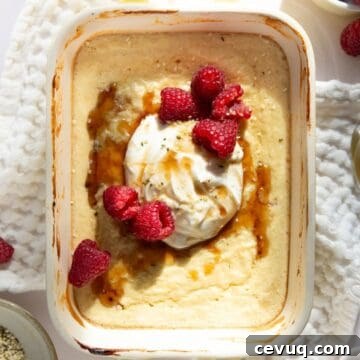 Healthy high protein pancake bowl topped with Greek yogurt, fresh raspberries, and maple syrup.