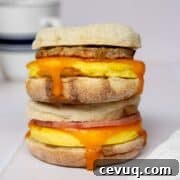 High-protein freezer breakfast sandwich with fluffy cottage cheese eggs, cheese, and chicken sausage on toasted English muffin.