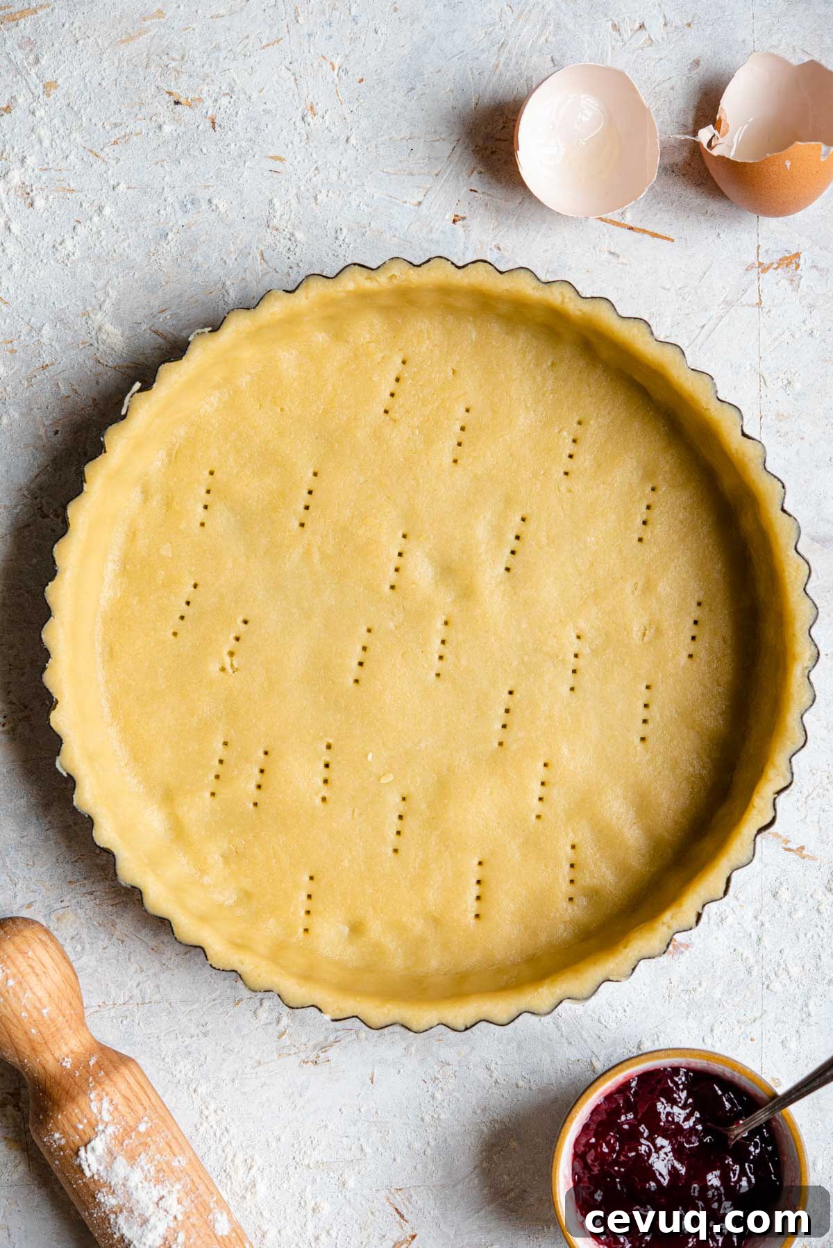An overhead shot of raw sweet shortcrust pastry in a pie case