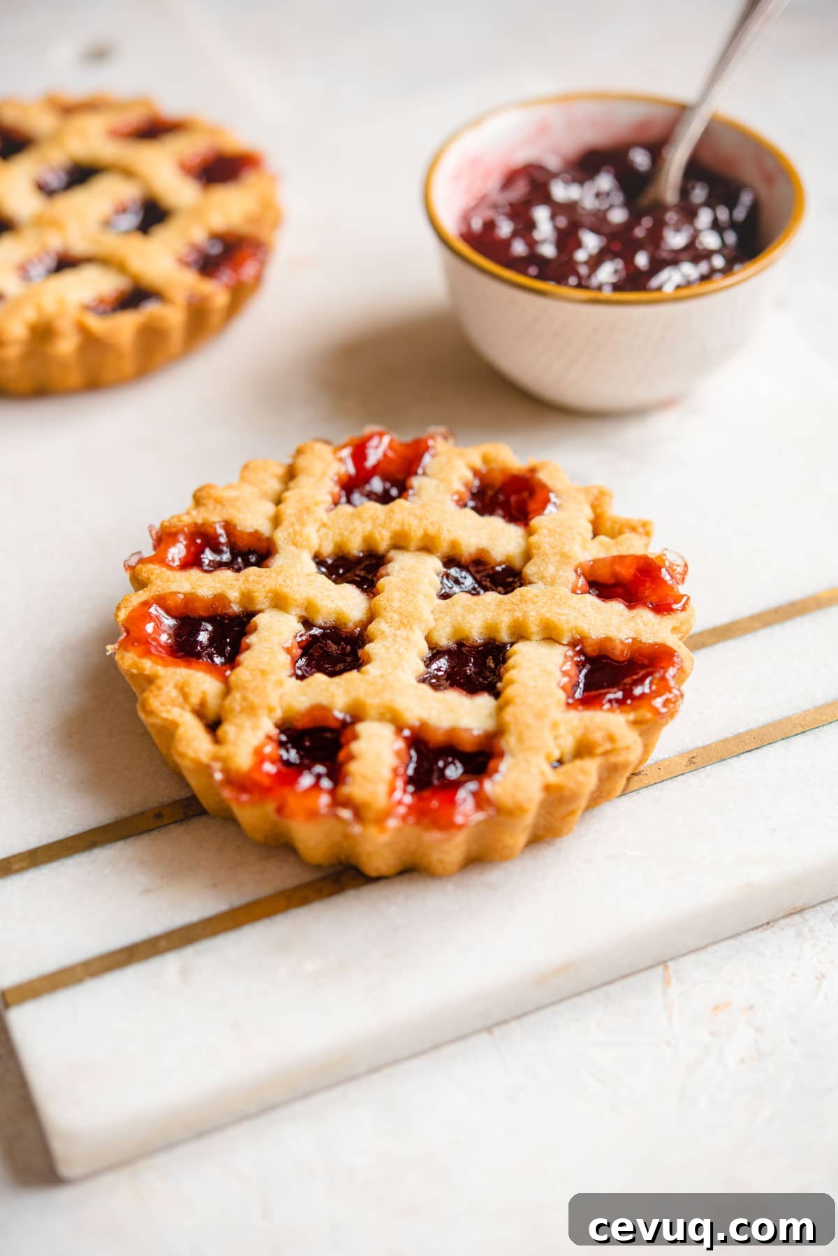 A mini Italian jam tart on a marble cutting board
