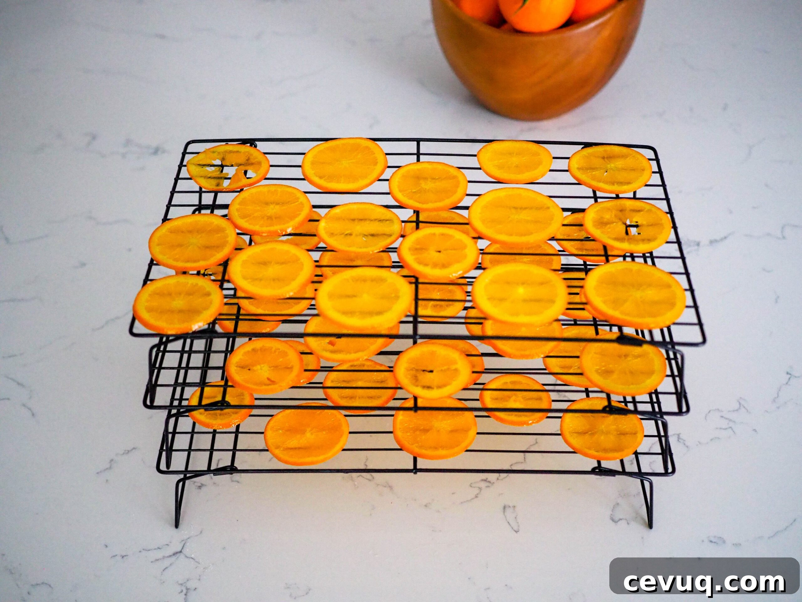 Stacked drying racks with orange slices on them.