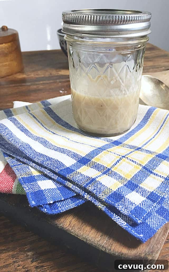 How to Save and Store Bacon Grease for Cooking and Flavor 3 A jelly jar with bacon grease, blue and white napkin, spoon and cutting board
