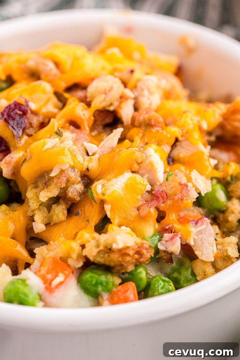 Turkey casserole with stuffing and veggies in a white bowl.