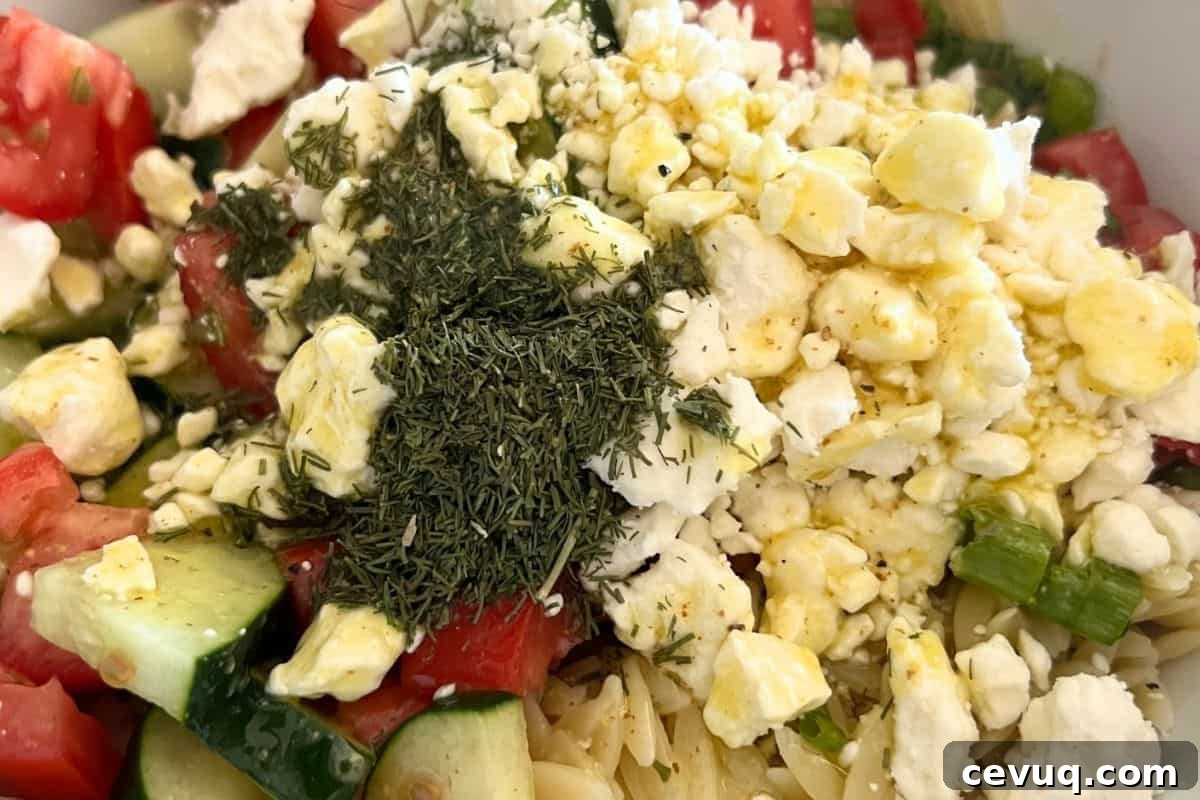 Greek orzo salad combined in a bowl.