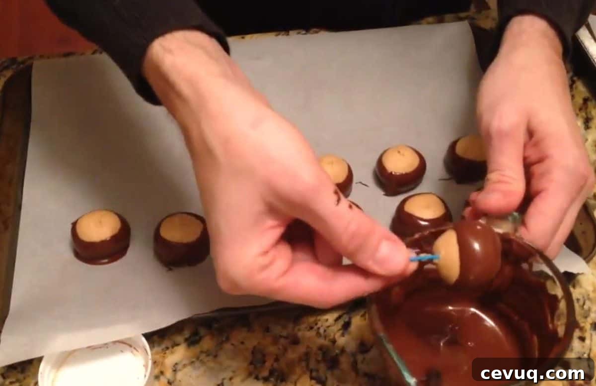 Dipping peanut butter balls into melted chocolate to make buckeyes.