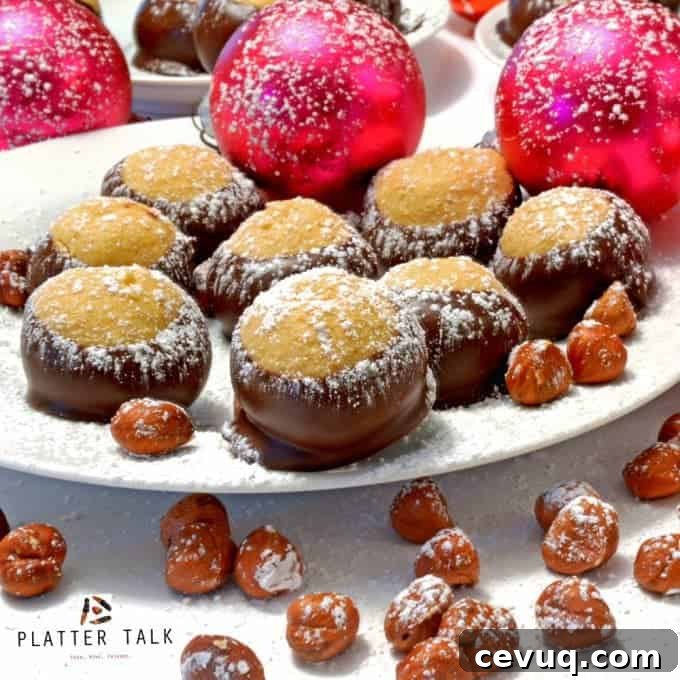 Festive plate of buckeye candies with hazelnuts and ornaments dusted with powdered sugar.