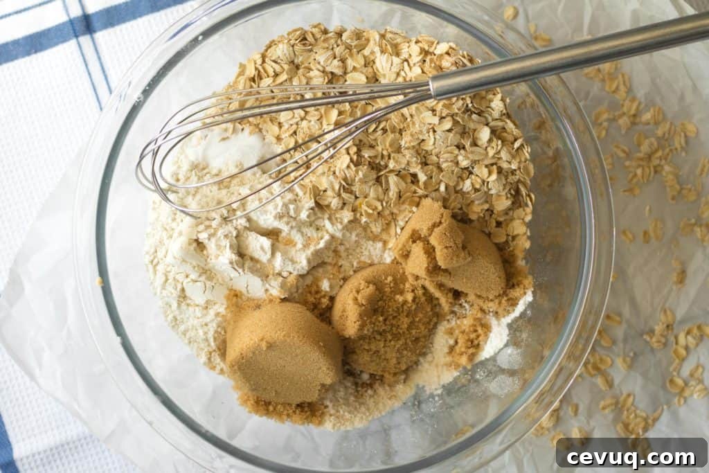 dry ingredients for apple cinnamon oatmeal breakfast muffins in a glass bowl with a whisk