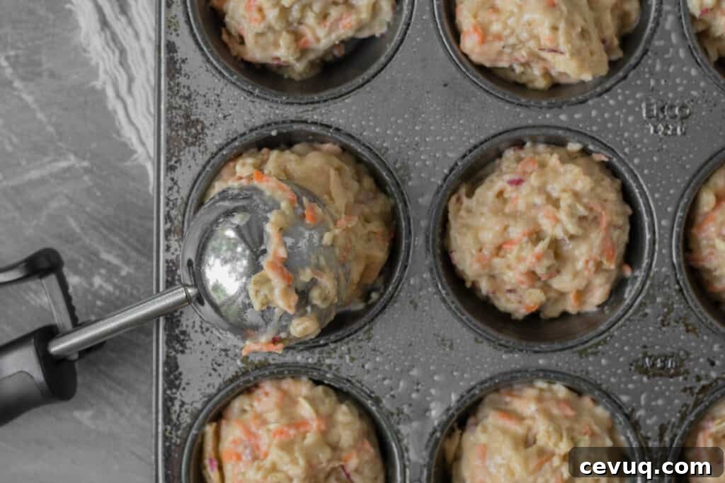 muffin batter being portioned into muffin tin