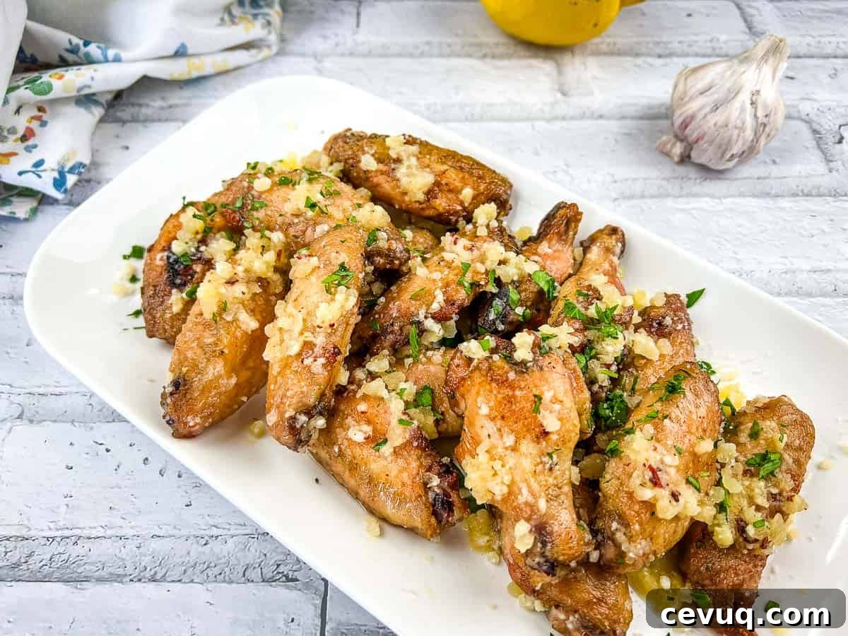 Chicken wings with garlic and Parmesan on a white plate.