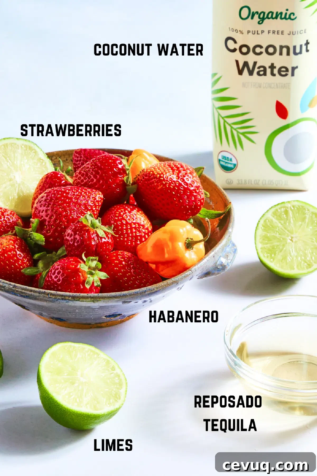 Ingredients to make strawberry habanero margaritas: tequila, strawberries, habaneros, limes, and coconut water.