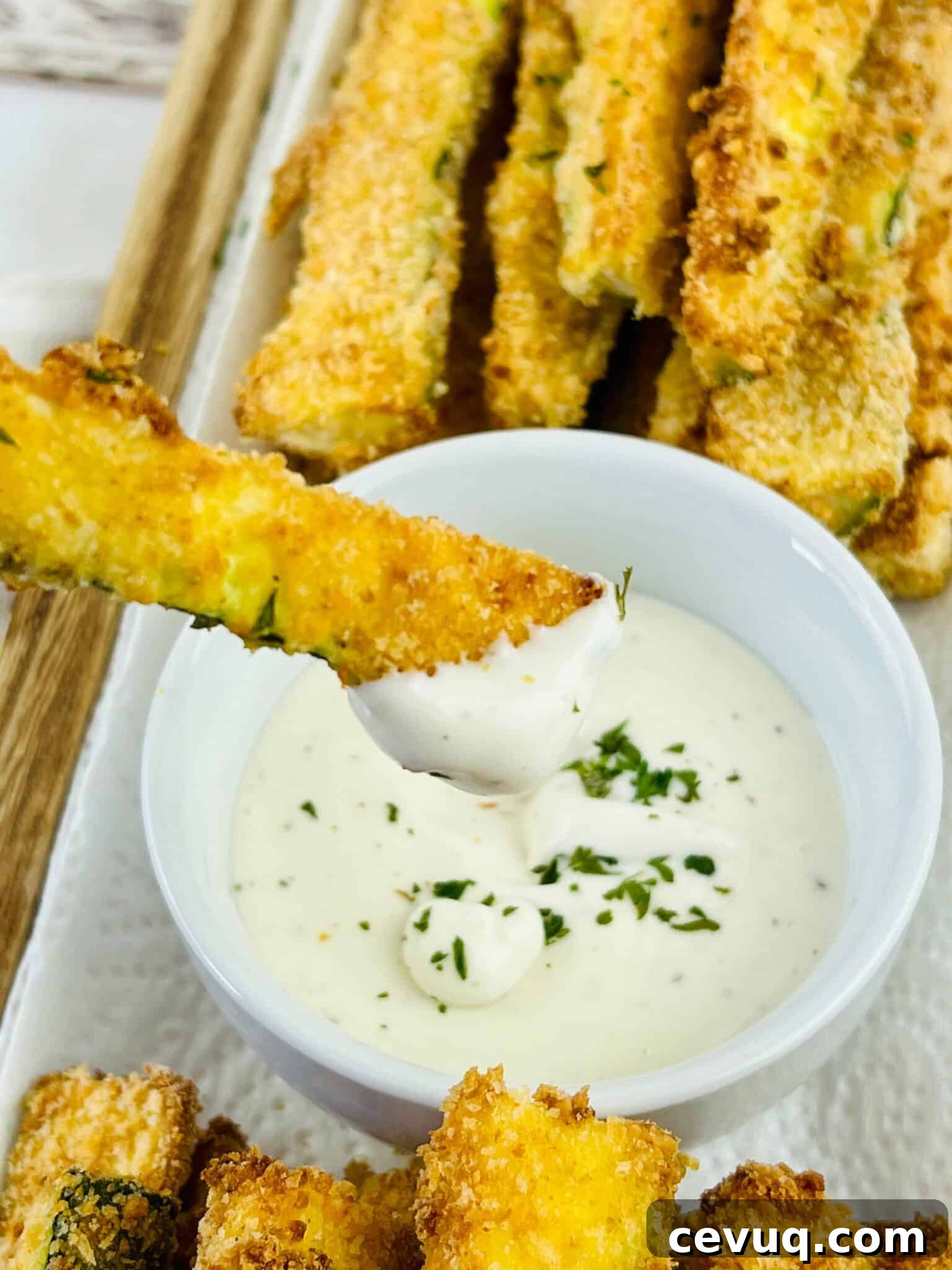 Dipping an oven baked zucchini fry in sauce.