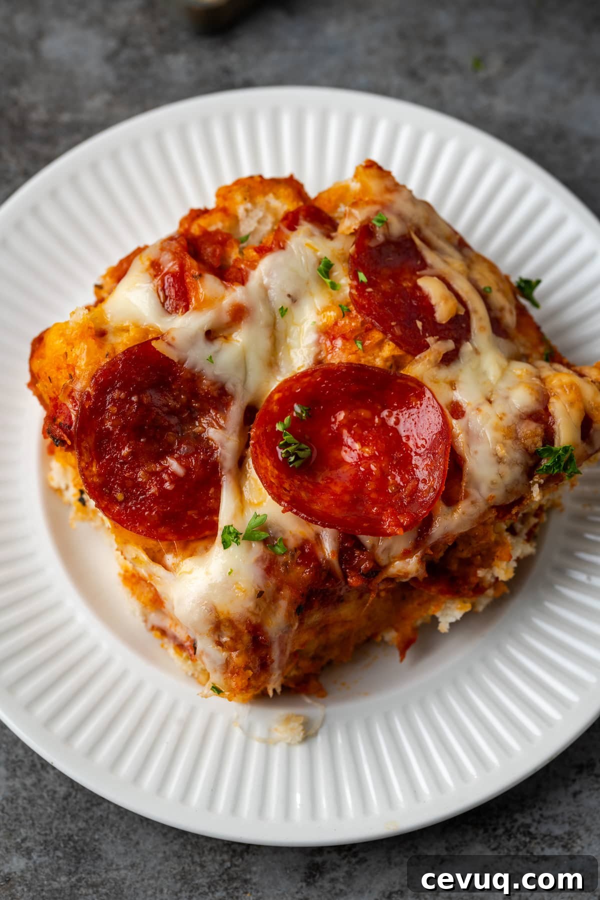 Overhead view of a serving of pizza casserole on a white plate.