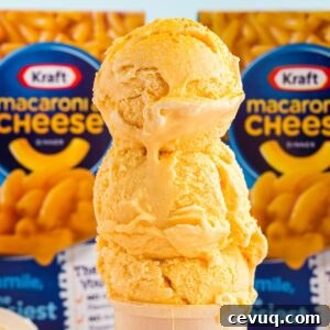 Copycat Mac and Cheese Ice Cream Recipe 12 Stack of scoops of Copycat Mac and Cheese Ice Cream, with boxes of Mac and Cheese in the back ground.