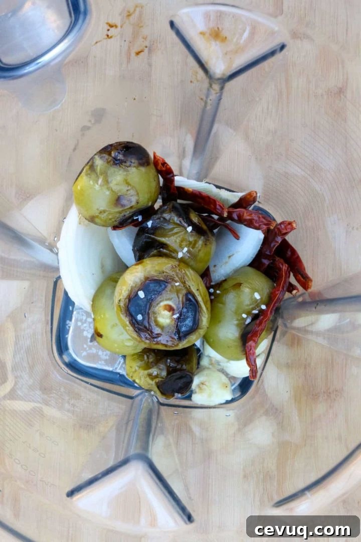 Tomatillos, chiles de arbol, onion and garlic in a blender.