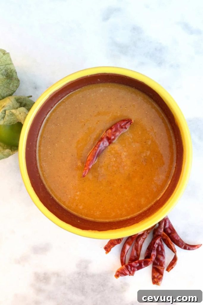 Roasted Tomatillo Salsa with a Chile de arbol and surrounded by more chiles and tomatillos