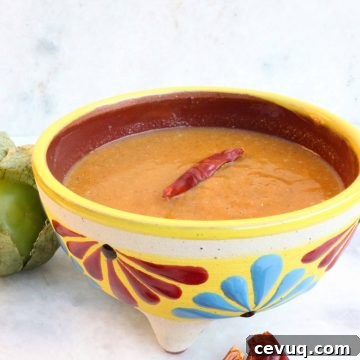 Roasted Tomatillo Salsa with a Chile de arbol and surrounded by more chiles and tomatillos