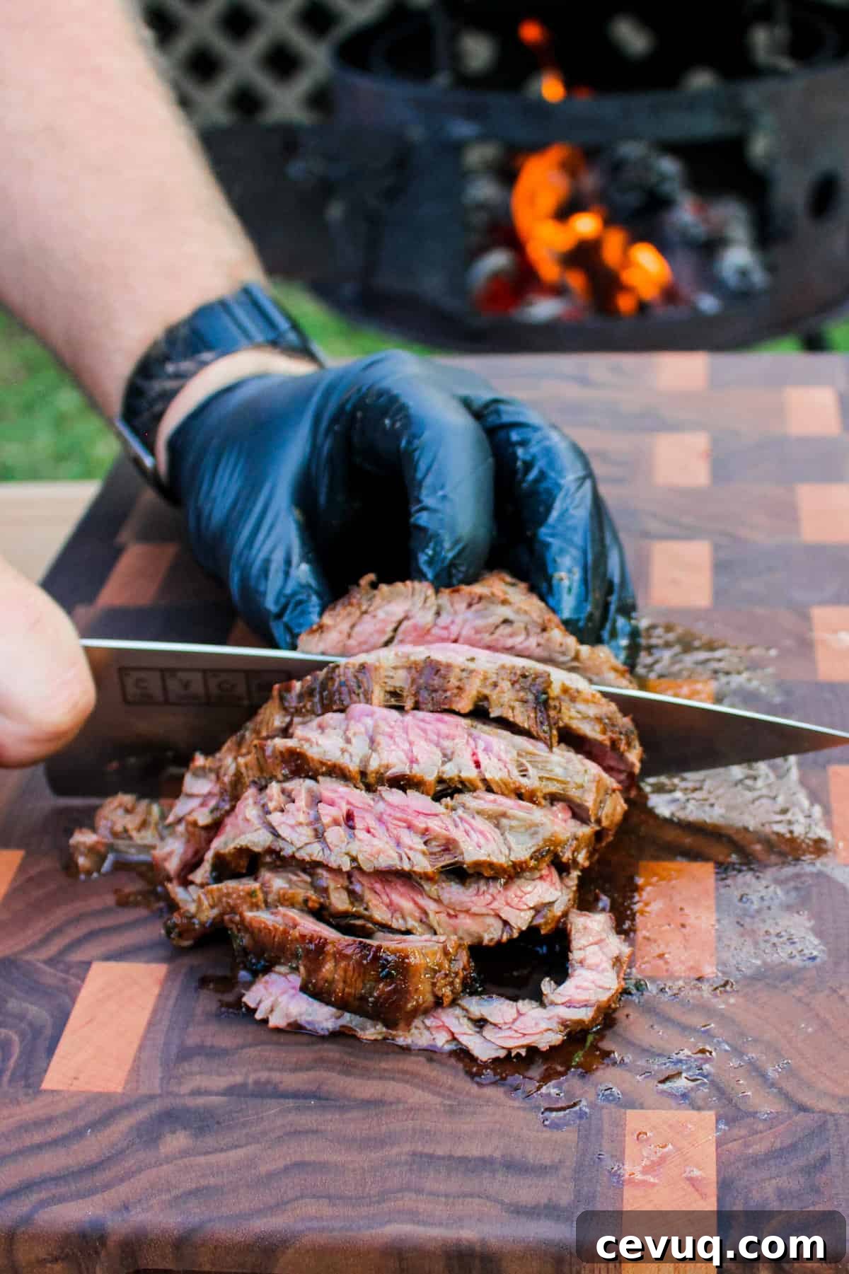 cooked steak being sliced on a cutting board