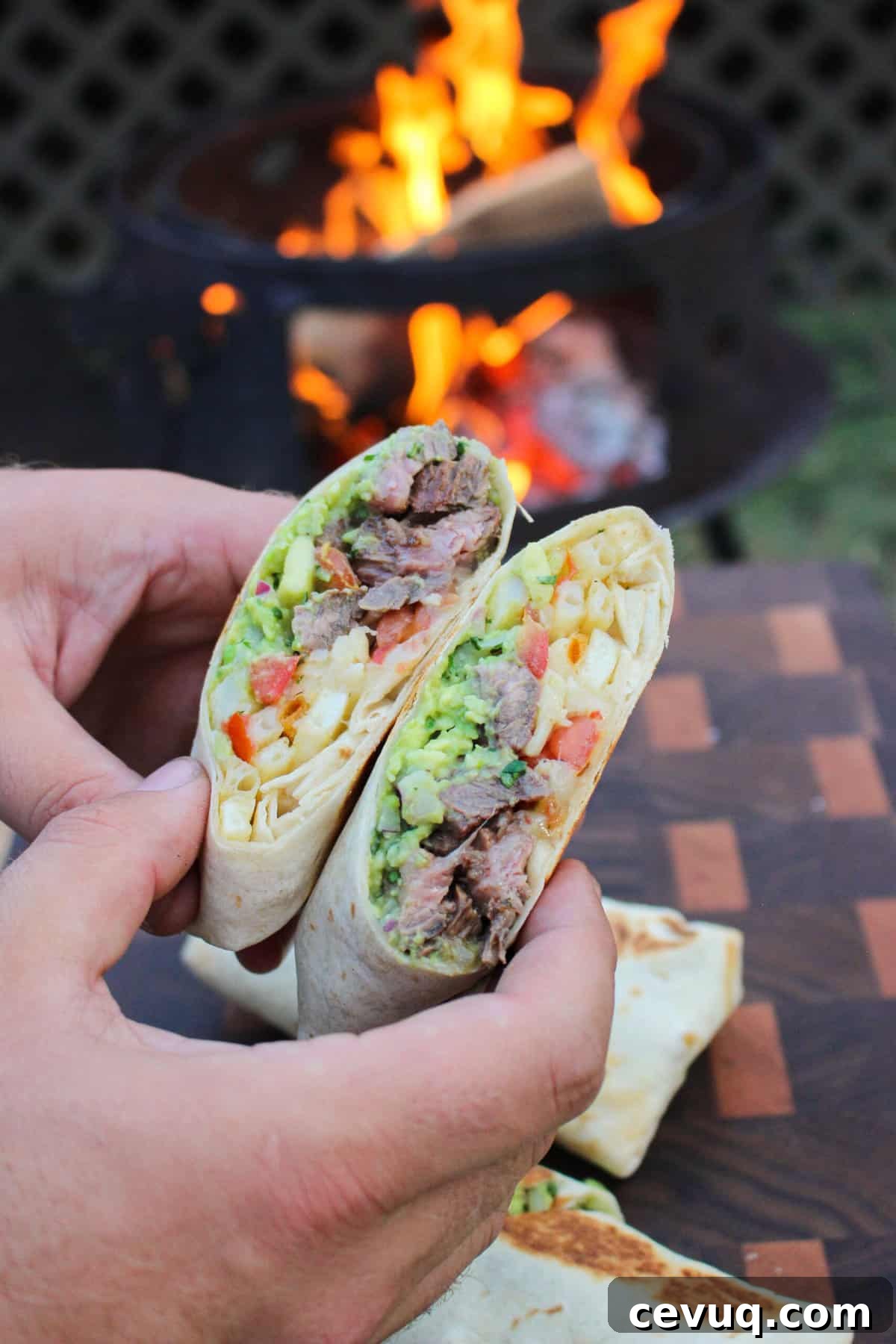 two halves of a california burrito held over a fire