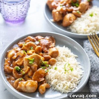 cashew chicken with rice on two plates with a glass of water