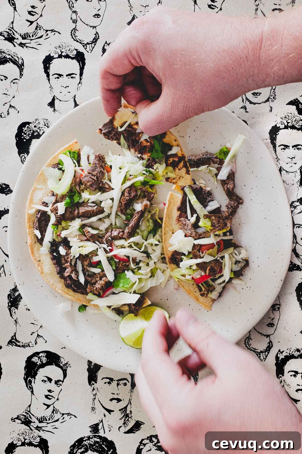 Hands break up a Mexican tlayuda. The background is a collage of sketches of Mexican artist Frida Kahlo