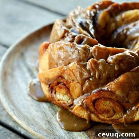Cinnamon Roll Coffee Cake in bundt pan scallops, dripping coffee glaze, round wooden cake plate, wooden table