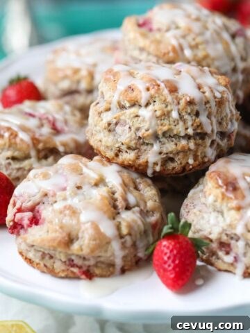 Strawberry biscuits on a white cake stand sitting on top of a blue surface.