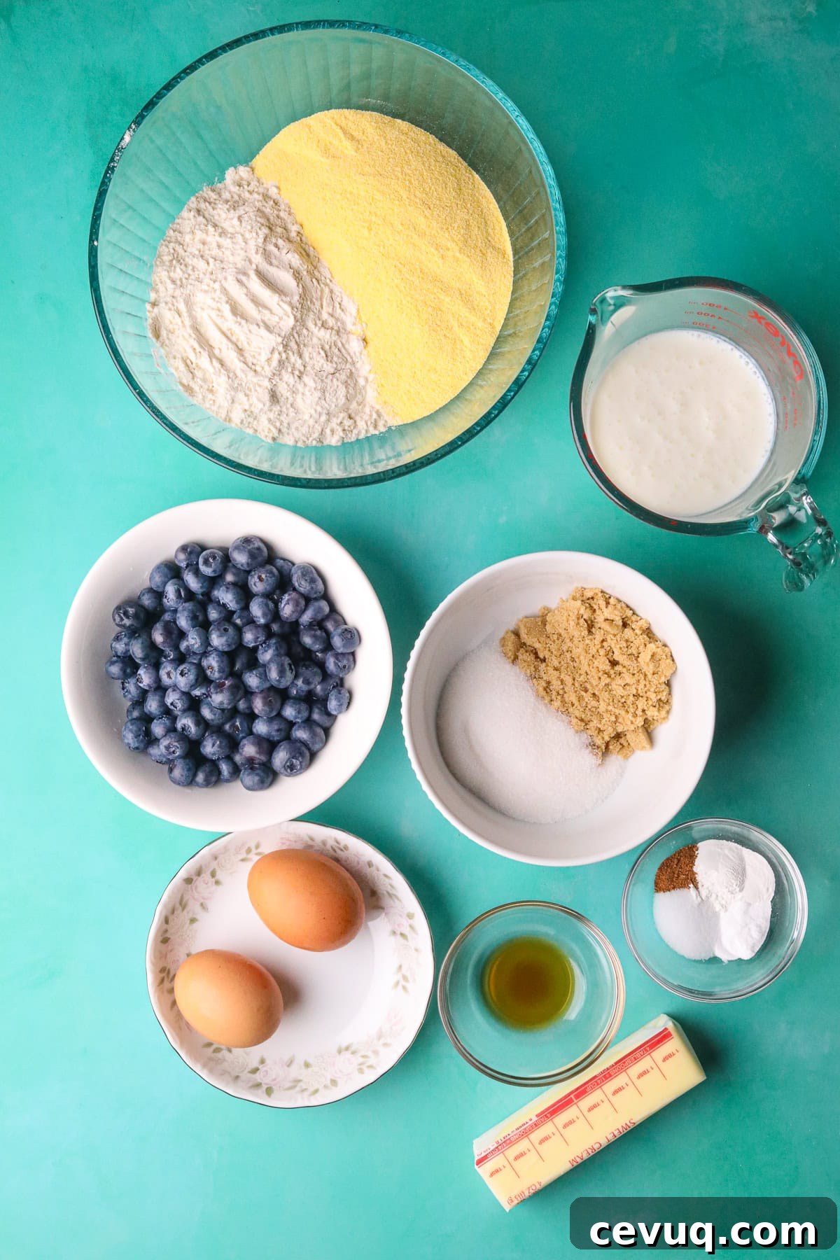 Blueberry cornbread ingredients with cinnamon honey butter arranged on a table top.
