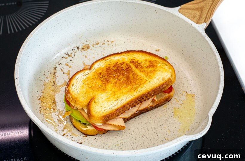 The two sliced of bread put together in the pan to make a sandwich. 