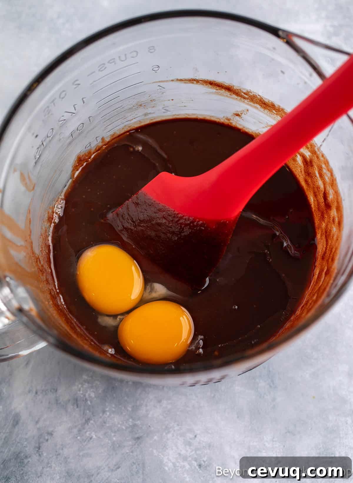 Mixing eggs into brownie batter.